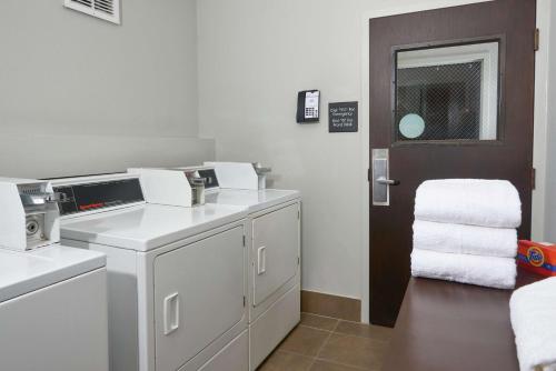 a white laundry room with a washer and dryer at Hampton Inn Juno Beach in Juno Beach