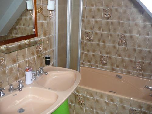 une salle de bain avec un lavabo et une baignoire dans l'établissement Kerbarbo, à Plouagat