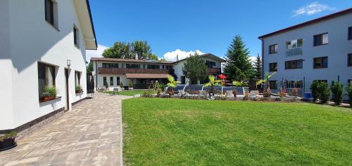 a courtyard of a building with a green lawn at Penzion Panorama in Liptovský Mikuláš
