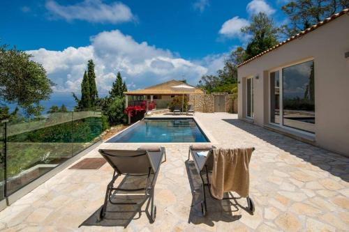 a patio with two chairs and a swimming pool at Terra villa by PaxosRetreats in Lákka