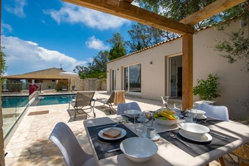 a table with food on it next to a pool at Terra villa by PaxosRetreats in Lákka
