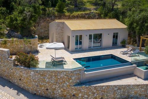 a villa with a swimming pool and a house at Terra villa by PaxosRetreats in Lákka