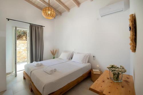 um quarto branco com uma cama e uma mesa em Terra villa by PaxosRetreats em Lákka