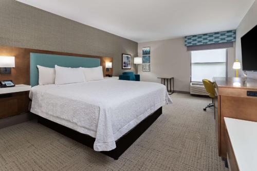 Habitación de hotel con cama grande y TV en Hampton Inn Perry, en Perry