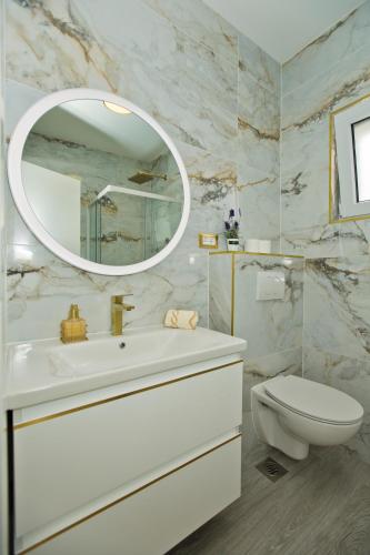 a bathroom with a sink and a toilet and a mirror at Luxury Apartment Veronika in Hvar