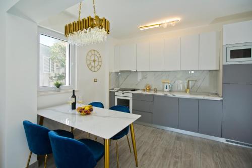 a kitchen with a white table and blue chairs at Luxury Apartment Veronika in Hvar