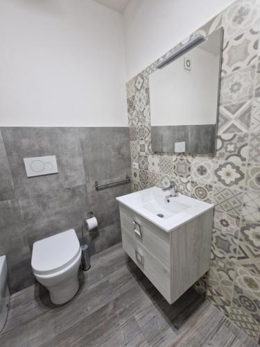 a bathroom with a toilet and a sink and a mirror at Hotel Porta Marmorea in Gubbio