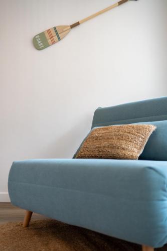 a blue couch in a living room with a lamp at Le Sable Doré - Piscine et parking in Capbreton