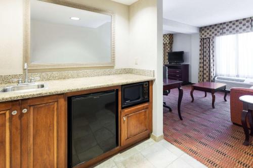 a kitchen with a sink and a living room at Hampton Inn Moss Point in Moss Point