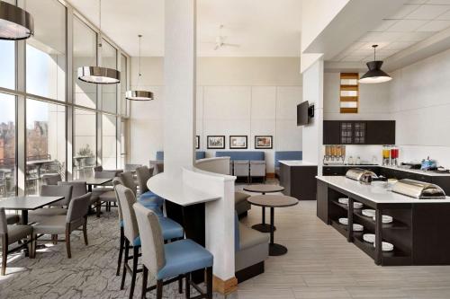 a restaurant with tables and chairs and a kitchen at Homewood Suites University City Philadelphia in Philadelphia