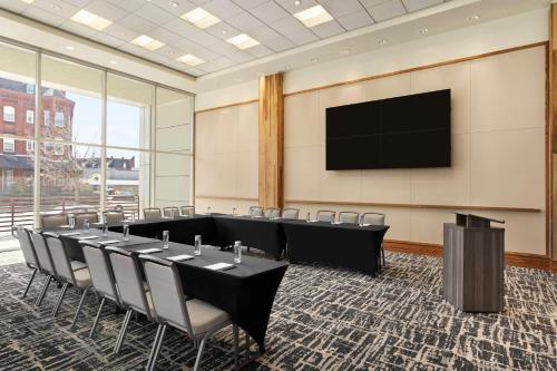 a conference room with tables and chairs and a flat screen tv at Homewood Suites University City Philadelphia in Philadelphia