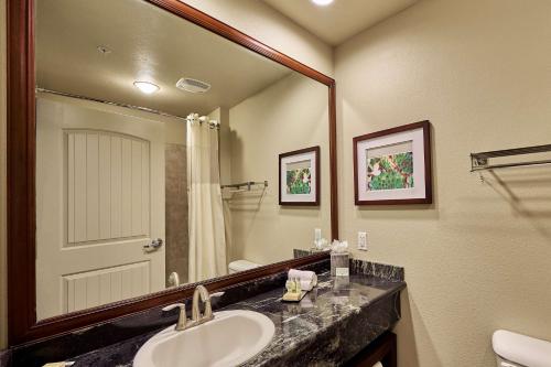 a bathroom with a sink and a large mirror at DoubleTree by Hilton Phoenix-Gilbert in Gilbert