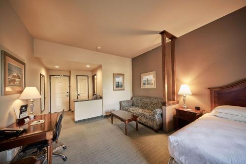 um quarto de hotel com uma cama, uma secretária e um sofá em DoubleTree by Hilton Phoenix-Gilbert em Gilbert