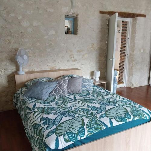 a bedroom with a bed with a blue and white comforter at Gite dans une ancienne corps de ferme D in Provins