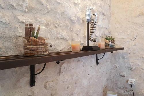 a shelf on a wall with candles and a lamp at Ancien corps de ferme in Poigny