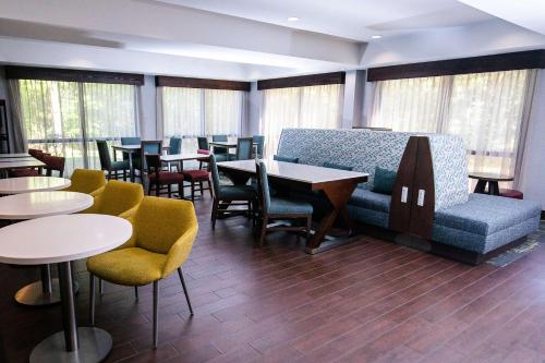 Counce的住宿－皮克威克達姆漢普頓酒店- 位於夏伊洛瀑布，一间设有桌椅和沙发的等候室