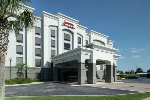a white building with a red sign on it at Hampton Inn & Suites Panama City Beach-Pier Park Area in Panama City Beach