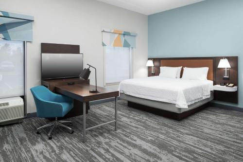 a hotel room with a bed and a desk with a computer at Hampton Inn & Suites Panama City Beach-Pier Park Area in Panama City Beach
