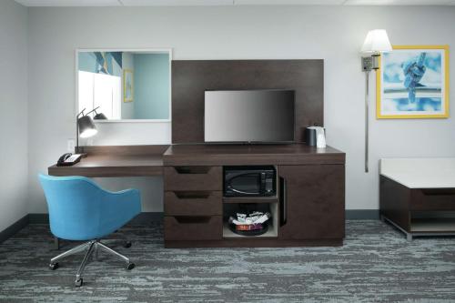 a room with a desk with a television and a chair at Hampton Inn & Suites Panama City Beach-Pier Park Area in Panama City Beach