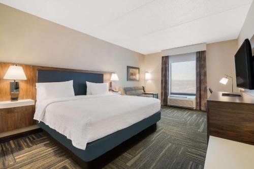 a hotel room with a bed and a television at Hampton Inn & Suites Plattsburgh in Plattsburgh