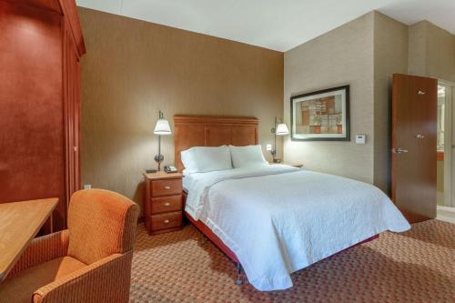 a hotel room with a bed and a desk and a chair at Hampton Inn East Peoria in Peoria