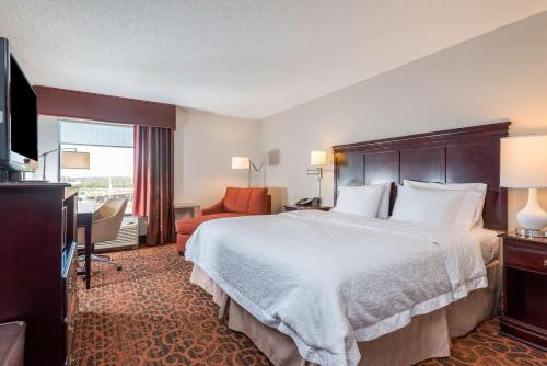 um quarto de hotel com uma cama grande e uma televisão em Hampton Inn Parkersburg/Mineral Wells em Mineralwells