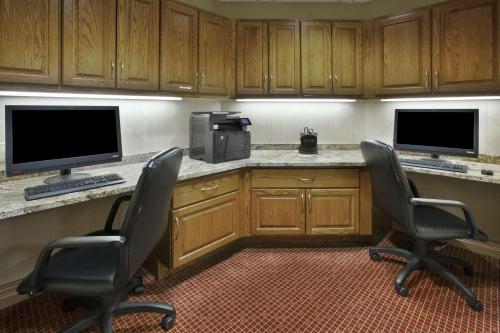 a kitchen with two chairs and a desk with two monitors at Hampton Inn & Suites Plattsburgh in Plattsburgh