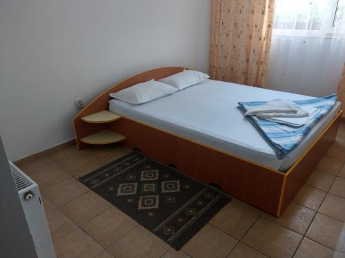 a small bedroom with a bed with a white mattress at Hotel Vila Alex in Costinesti