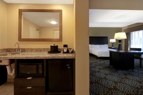 a hotel room with a sink and a bedroom at Hampton Inn & Suites Pensacola/Gulf Breeze in Gulf Breeze