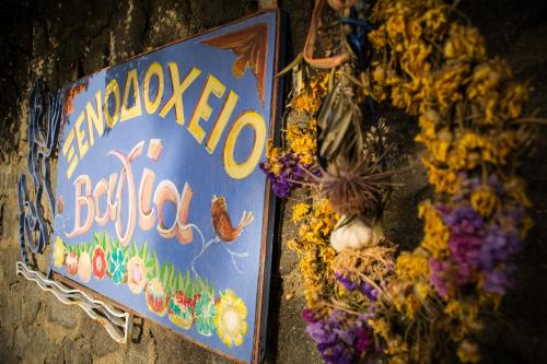 a sign for a restaurant with a bunch of flowers at Vagia Traditional, Aegina Island in Vaia
