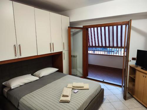 1 dormitorio con 1 cama con 2 toallas en Appartamento Magnolia, en Pomezia