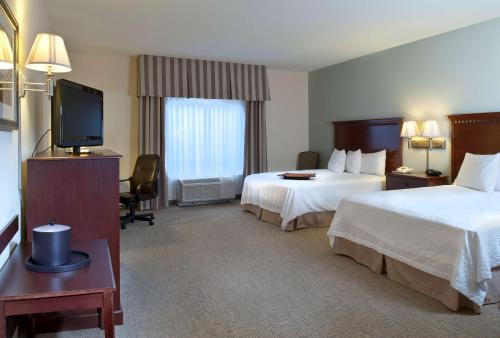 a hotel room with two beds and a flat screen tv at Hampton Inn & Suites Prescott Valley in Prescott Valley