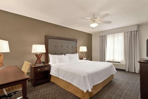 a bedroom with a large white bed and a desk at Homewood Suites by Hilton Dover - Rockaway in Dover