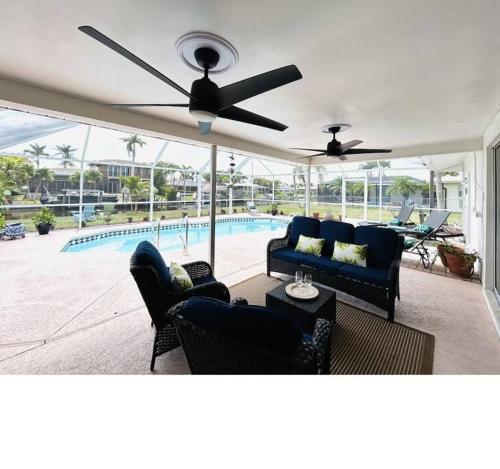 uma sala de estar com 2 sofás e uma ventoinha de tecto em Pelican Waterfront Paradise with Boat Lift em Cape Coral