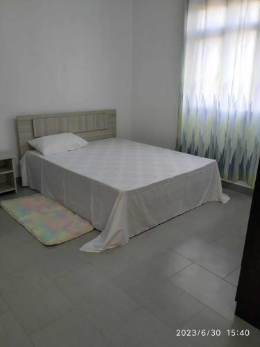 a bedroom with a bed with a white bedspread at A 7 Villa in Quartier Militaire