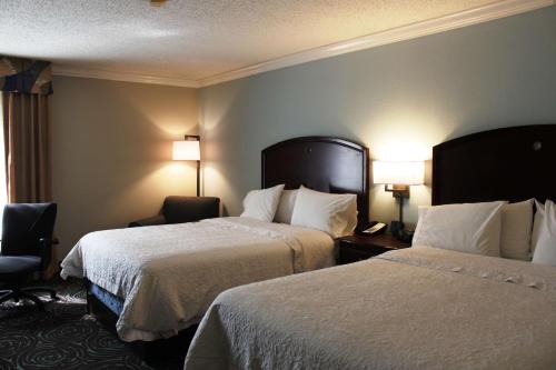 a hotel room with two beds and a window at Hampton Inn Perry in Perry