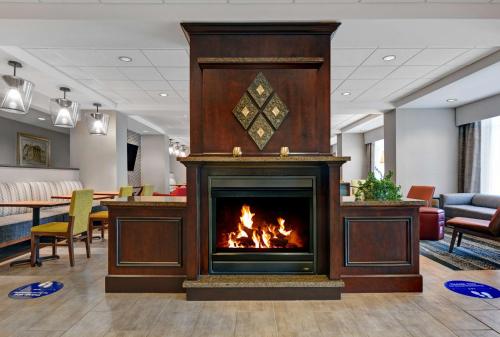 a fireplace in a hospital lobby with a fire at Hampton Inn Bath - Brunswick Area , ME in Bath