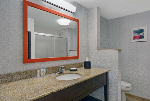 a bathroom with a sink and a mirror and a toilet at Hampton Inn Bath - Brunswick Area , ME in Bath