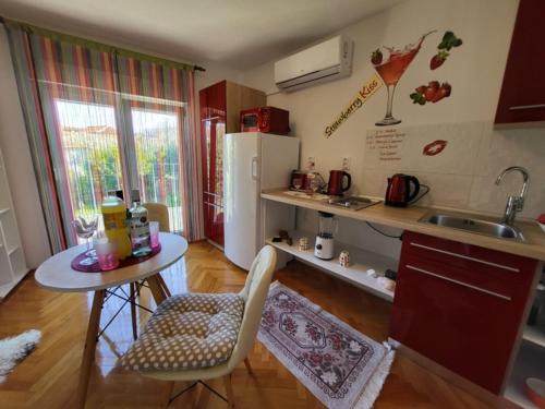 een kleine keuken met een tafel, een wastafel en een koelkast bij Apartments LukaS in Tisno