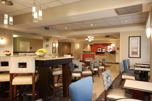 a restaurant with chairs and tables and a bar at Hampton Inn Pennsville in Pennsville