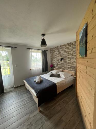 a bedroom with a bed and a brick wall at Pokoje Goscinne u Naglaka Willa Zab in Ząb