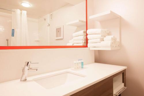 een badkamer met een wastafel, een spiegel en handdoeken bij Hampton Inn Pennsville in Pennsville