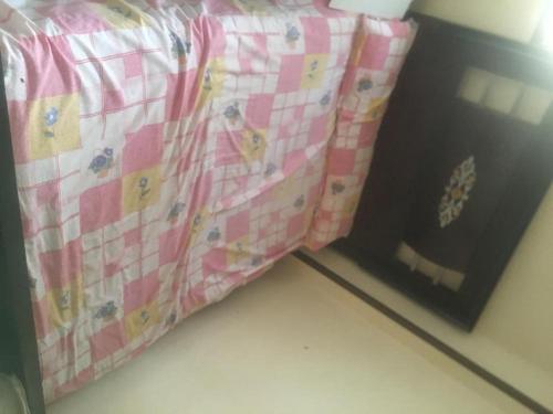 a bed with a pink and white checkered sheet at Grand M 