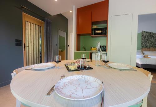 a dining room table with glasses of wine on it at Hôtel - Lodges de Lemptégy in Saint-Ours