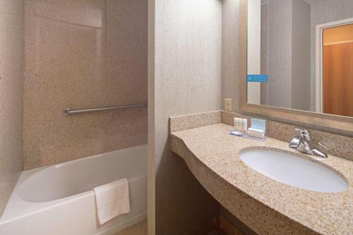 a bathroom with a sink and a bath tub at Hampton Inn & Suites Bremerton in Bremerton