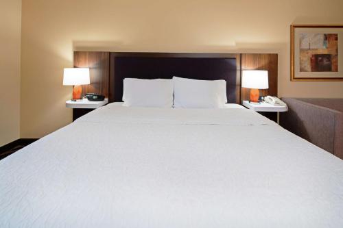 a large white bed in a hotel room with two lamps at Hampton Inn & Suites Bremerton in Bremerton