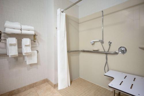 W łazience znajduje się prysznic z zasłoną prysznicową. w obiekcie Hampton Inn Raynham-Taunton w mieście Raynham