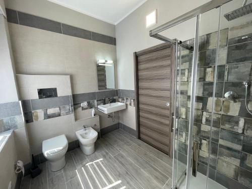 a bathroom with a toilet and a sink and a shower at APPARTAMENTO ELEGANTE CARBONIA in Carbonia