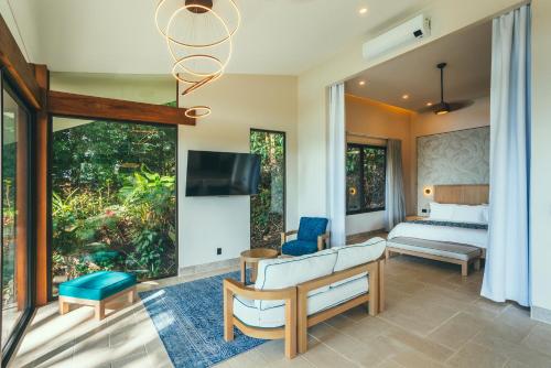 um quarto com uma cama e uma televisão num quarto em Los Altos Resort em Manuel Antonio