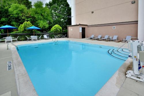 a large blue swimming pool with chairs and umbrellas at Hampton Inn Raleigh/Durham Airport in Morrisville